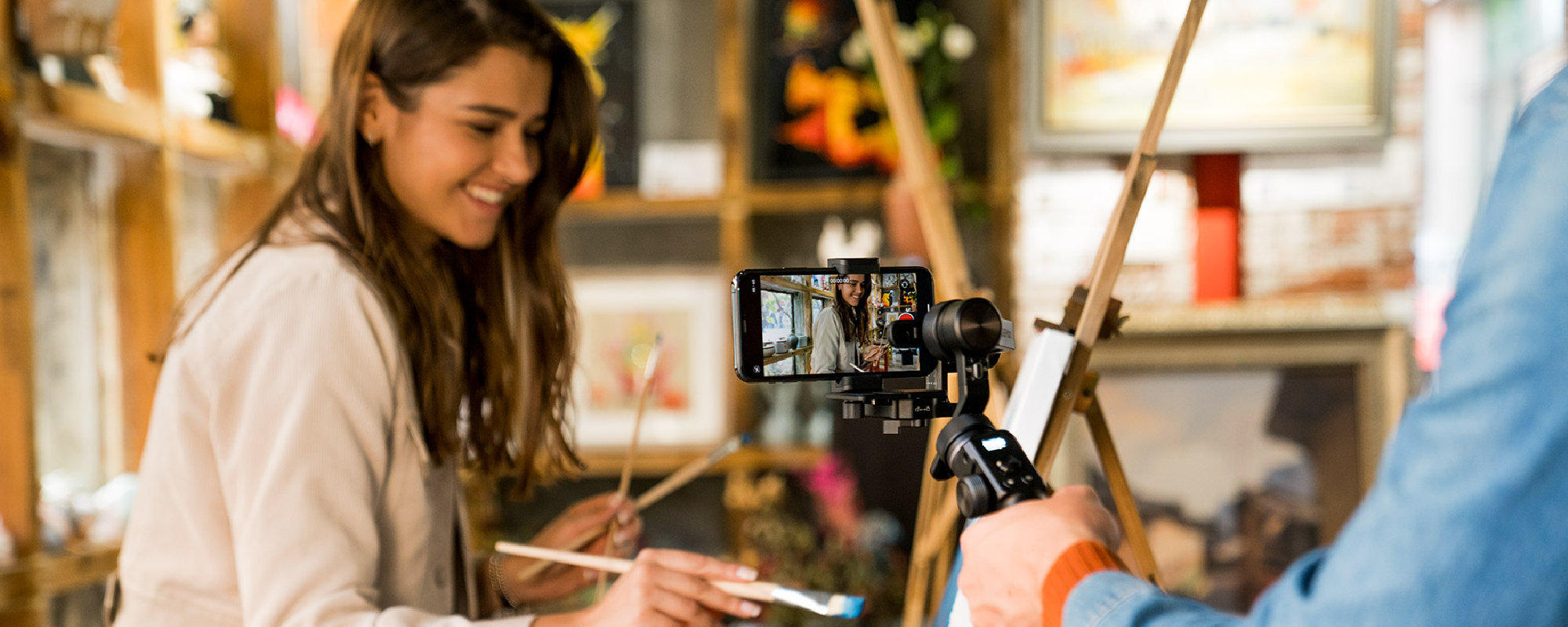 Dziewczyna maluje obraz będąc filmowana smartfonem na gimbalu FeiyuTech G6 Max